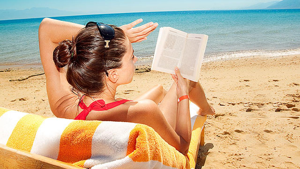 Девушка на пляже с книжкой